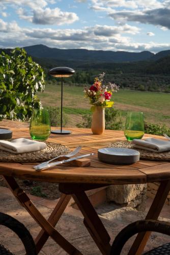a wooden table with plates and wine glasses on it at La Torre del Visco - Relais & Châteaux in Fuentespalda