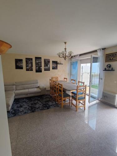 une salle à manger avec une table, des chaises et un canapé dans l'établissement Maison 5 pièces jardin, à Aubervilliers