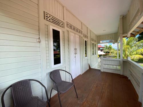 a porch of a house with two chairs and a window at A beautiful and Spacious Rumah Manado 2 Bedrooms with Bathrooms Villa Marion Tomohon in Tomohon