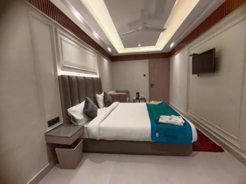 a hotel room with a bed and a television at Hotel Gagan Suite in Kānpur
