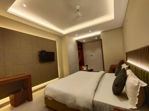 a hotel room with a bed and a television at Hotel Gagan Suite in Kānpur