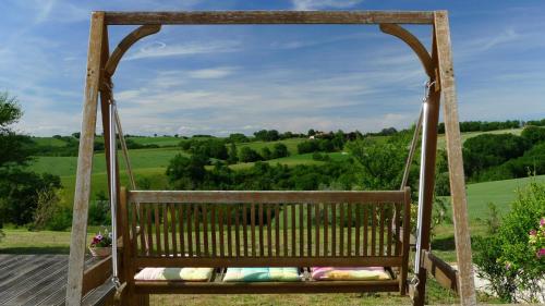 une balançoire avec vue sur les collines verdoyantes dans l'établissement Les hauts de Saint Christaud, à Pallanne