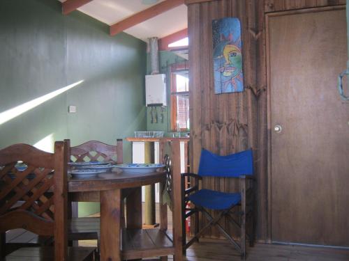 Habitación con mesa, sillas y puerta en Cabañas Caleta San Pedro, en La Serena