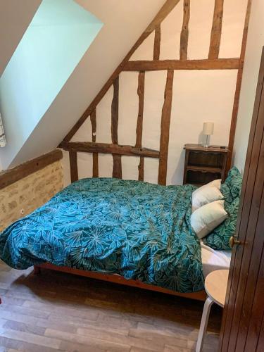 a bedroom with a bed with a blue comforter at Jolie maison normande ancienne in Saint-Laurent-du-Mont