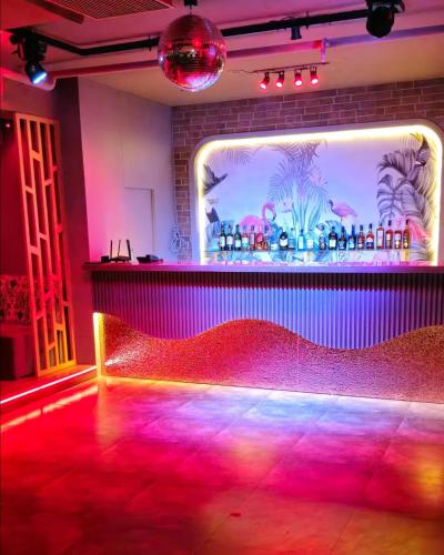 a room with a bar with a red dance floor at Hotel Gagan Suite in Kānpur