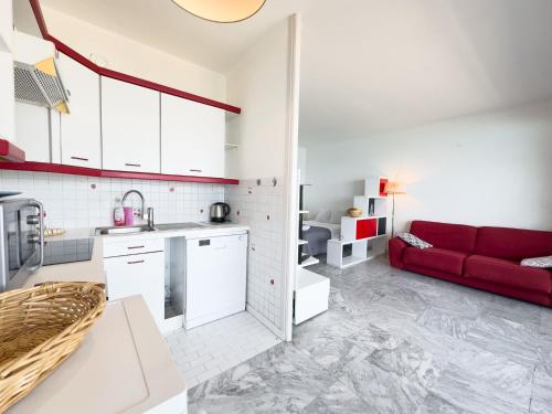 Il comprend une cuisine et un salon avec un canapé rouge. dans l'établissement Holiday on the Beach, Bnb Rickeys, à Roquebrune-Cap-Martin