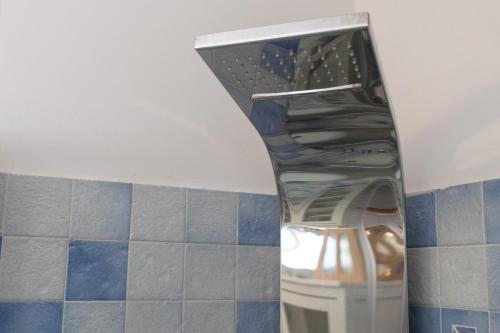 a glass shelf in a bathroom with blue tiles at Villa Lorenz in Putignano