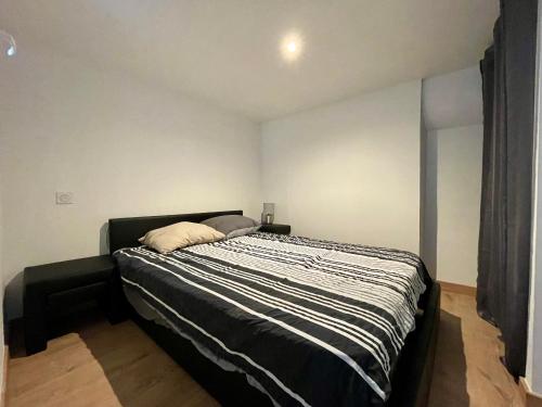 une chambre avec un lit avec une couette noire et blanche dans l'établissement Duplex de bezons - parking - Entre centre-ville et cité médiévale, à Carcassonne