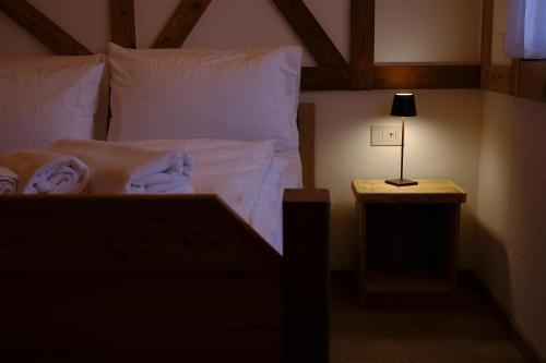 a bedroom with a bed with white sheets and a lamp at b&b da Anna in Pergine Valsugana