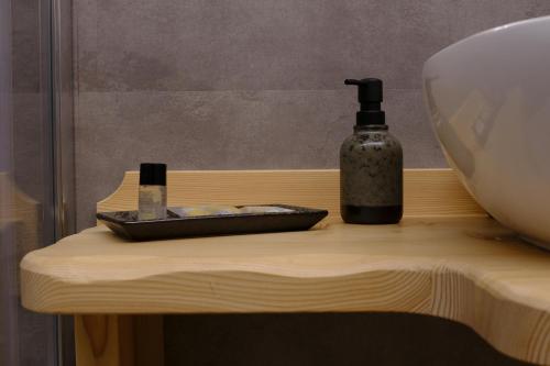 a bottle of soap sitting on a wooden table at b&b da Anna in Pergine Valsugana