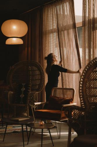 a woman is looking out of a window at 2Places Soul in Lörrach