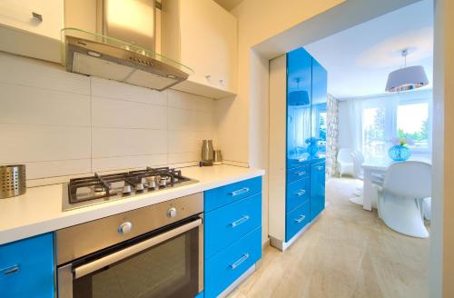 a kitchen with blue cabinets and a sink at Villa Vinodol *with great sea view and pool in Novi Vinodolski