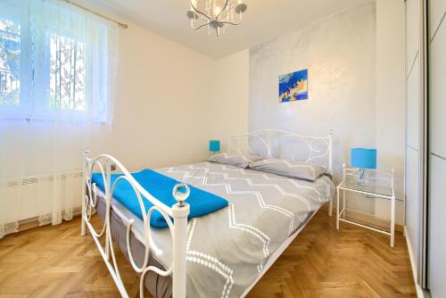 a white bed in a white bedroom with a window at Villa Vinodol *with great sea view and pool in Novi Vinodolski