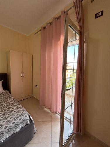 a bedroom with a bed and a sliding glass door at Rest House in Vlorë