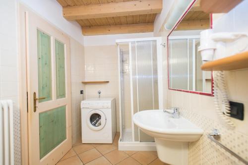 Un baño con lavadora y lavabo. en Casa Tomaselli, en Pellizzano