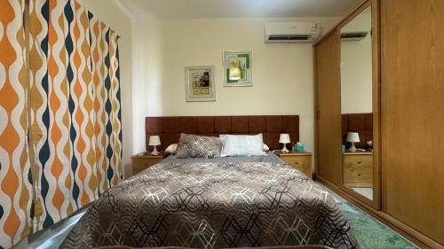 a bedroom with a bed and a large mirror at Private chalet in Amwaj north coast 2 bed room and 2 bath امواج الساحل الشمالي شاليه غرفتين واتنين حمام مفروش ومكيف بالكامل in El Alamein