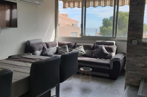 a living room with a couch and some windows at Duplex apartment with beautiful sea view in Saint-Raphaël