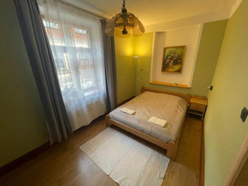 a small bedroom with a bed and a window at Katrīnas apartamenti in Kuldīga