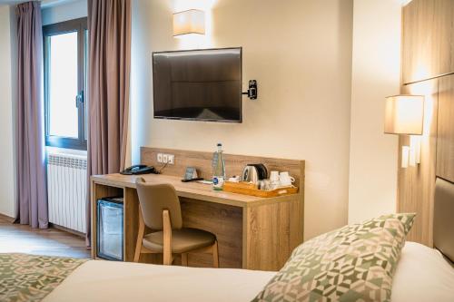 a hotel room with a desk with a television at Hotel Princesa Parc in Arinsal