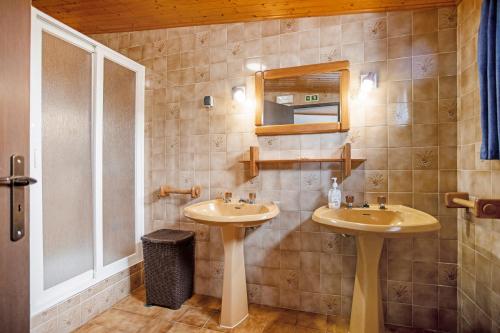 a bathroom with two sinks and a mirror at Moinho das Esteveiras in A dos Cunhados