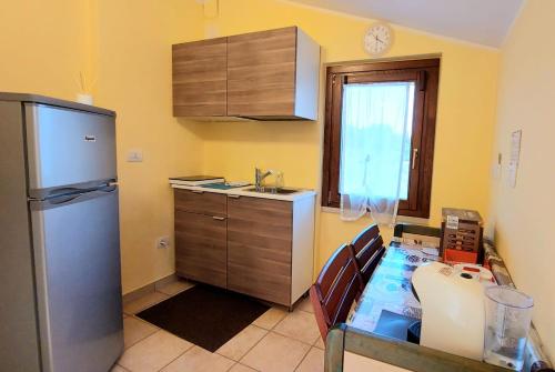 B&B Villa Maria Paola - Alloggi Temporanei Isernia في إيسيرنيا: مطبخ به ثلاجة وطاولة بداخله