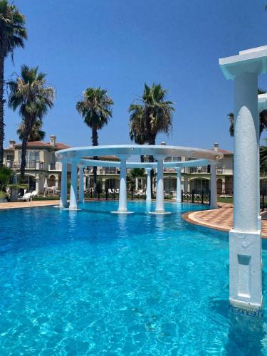 einen Pool mit blauem Wasser und Palmen in der Unterkunft Villa B&D Lou in Fethiye