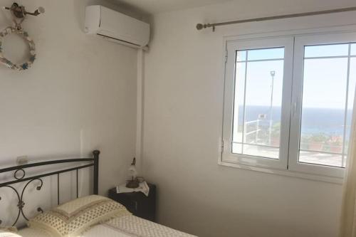 a bedroom with a bed and a large window at Κτήμα Καστέλι in Paralia Demonias