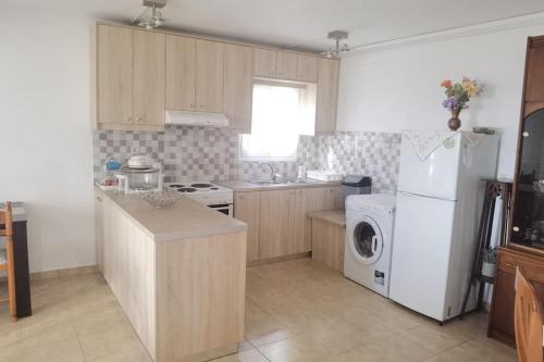 a kitchen with a white refrigerator and a washer and dryer at Κτήμα Καστέλι in Paralia Demonias