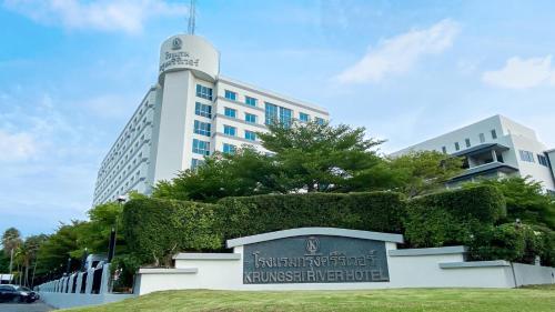 a large white building with a sign in front of it at Krungsri River Hotel in Phra Nakhon Si Ayutthaya