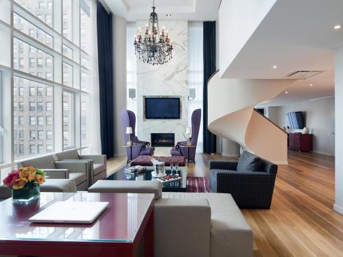 a living room filled with furniture and a large window at Royalton Park Avenue in New York
