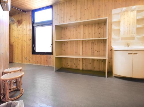 a room with wooden walls and shelves and a window at Hotel LC Gifu Hashima in Hashima