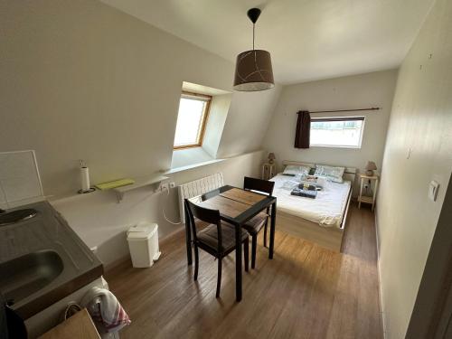 a small room with a bed and a table and chairs at Studio Felix 2 in Nesle