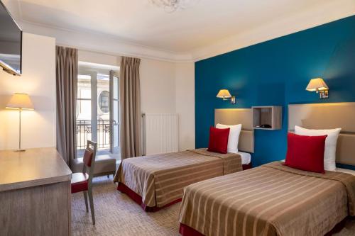 A bed or beds in a room at Hôtel Saint Pierre