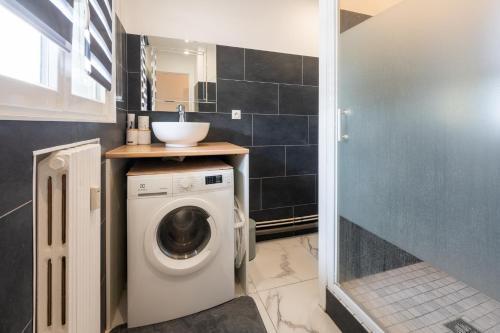 a bathroom with a washing machine and a sink at Le Studio du commandant in Évreux