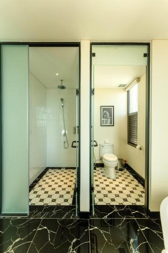 a bathroom with a shower and a toilet at Charmant Suites a Boutique Hotel Can Tho in Can Tho