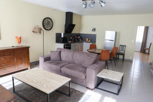 a living room with a couch and a table at Chablis Appart in Chablis