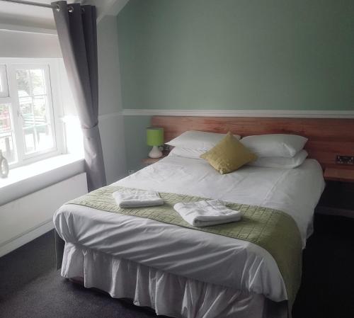 a bedroom with a bed with two towels on it at Brewers Lodge in Blackwood