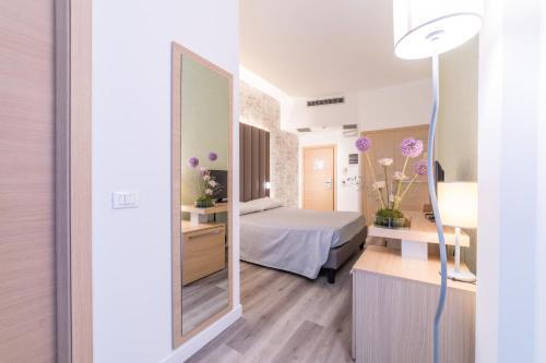 a hotel room with a bed and a mirror at Hotel Mioni Royal San in Montegrotto Terme