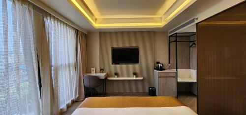 a hotel room with a bed and a tv at Dragonfly Hotel - The Art Hotel in Mumbai