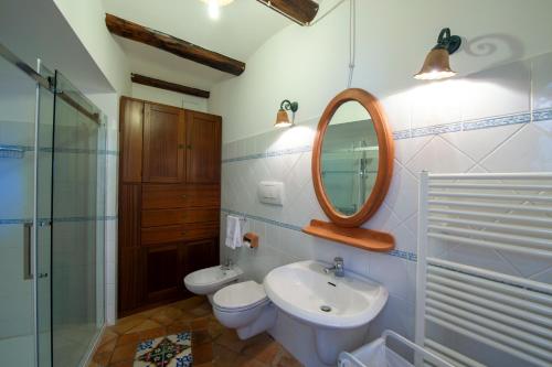 a bathroom with a sink and a mirror and a toilet at Casa Allegra in Praiano