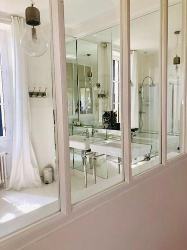 une salle de bain avec deux lavabos et un grand miroir dans l'établissement Maison Mercy, à Saint-Gervais