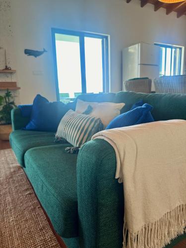 a green couch with pillows on it in a living room at A Casa do Jaime in Prainha de Baixo
