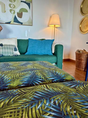 a bedroom with a green couch and a bed at A Casa do Jaime in Prainha de Baixo