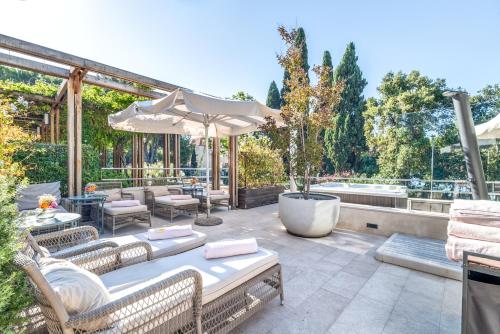 a patio with a table and chairs and an umbrella at Hotel Park Split in Split