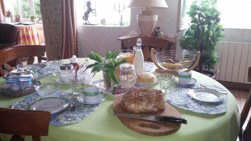 Relais De La Haute Pommeraye في Apremont: طاولة عليها قماش الطاولة الخضراء مع الطعام