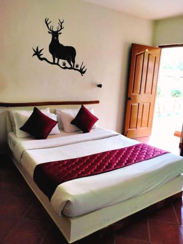 a bedroom with a bed with a deer on the wall at The Country Club Wildlife Resorts in Bandipūr