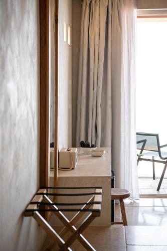 a room with a table and a chair and a window at The Theodore Boutique Hotel- adults only 16 plus in Agia Marina Nea Kydonias