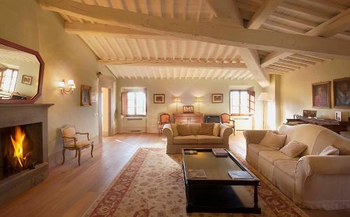 a living room with a couch and a fireplace at Castello Pomino in Rufina