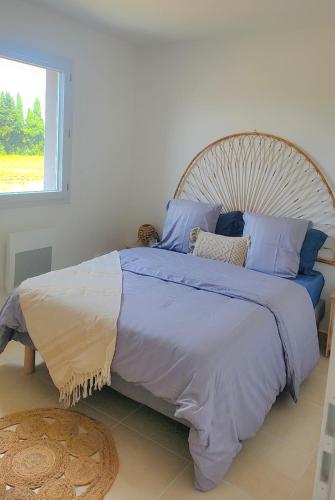une chambre avec un grand lit avec des oreillers bleus dans l'établissement Maison cosy jardins et détente, à Montélimar