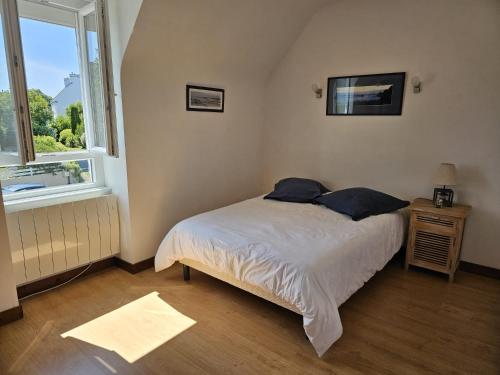 une petite chambre avec un lit et une fenêtre dans l'établissement Maison spacieuse avec jardin clos, vélos à disposition, plages à 2 kms, à Tréffiagat